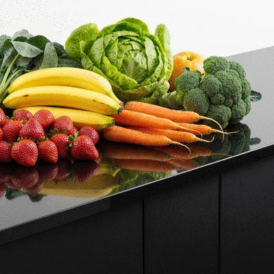 Fiber supplements next to a bowl of fresh fruits and vegetables